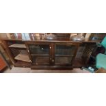A 2.2m antique mahogany break front cabinet with adjustable shelves enclosed by two central glazed
