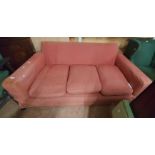 A 1.95m vintage three seater settee with faded fitted cover and cushions