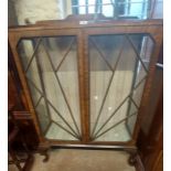 A 88cm 1930's walnut display cabinet with adjustable glass shelves enclosed by a pair of beaded