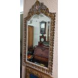 A modern white painted and parcel gilt framed ornate bevelled wall mirror with pierced pediment,