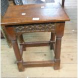 An antique oak coffin stool with decorative carved blind fretwork apron, set on an open stretcher