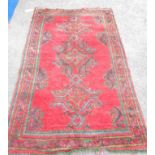 A modern handmade wool Tabriz style rug with central motifs within a wide border on red ground -