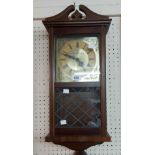 A stained wood cased wall timepiece with quartz movement