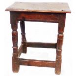An 18th Century coffin joint stool, set on an open stretcher base with turned supports - wear