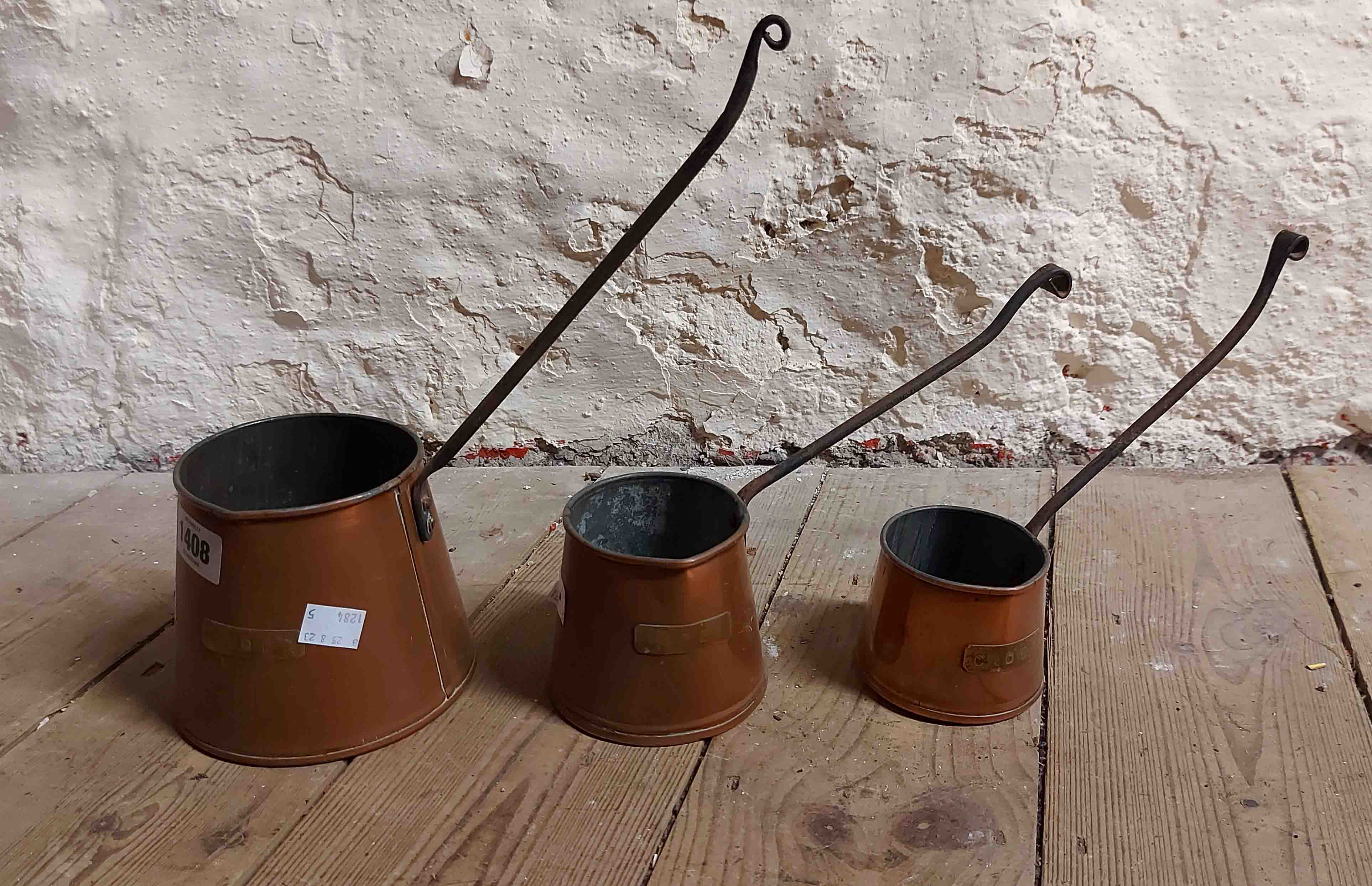 A set of three vintage copper cider measures with wrought iron handles