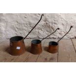 A set of three vintage copper cider measures with wrought iron handles