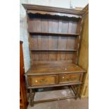 A 1.06m old oak dresser in the antique style with two shelf open plate rack over a base with two