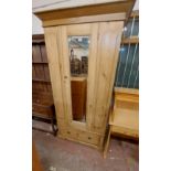 A 1m Edwardian stripped pine single wardrobe with hanging space enclosed by a bevelled mirror