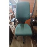 A modern flat pack desk and office chair with green upholstery