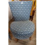 A vintage boudoir chair with repeat pattern tapestry upholstery and circular seat, set on swept