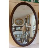 A 1920's oak framed bevelled oval wall mirror