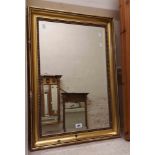 A reproduction gilt framed bevelled oblong wall mirror with beaded border - slight damage to frame