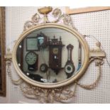 An antique Georgian style Adam Revival ornate oval wall mirror with urn pediment, flanking Sphinx