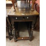 A 1.52m antique oak gateleg dining table set on barley twist supports