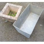 A concrete planter of tapered square form, set on wrought iron scroll feet - sold with a