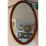 An Edwardian mahogany and strung framed bevelled oval wall mirror