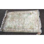 A handmade Oriental mat with faded design on pale ground - 1.25m X 80cm