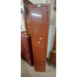 A red painted metal four gun cabinet with key