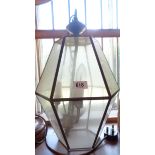 An old metal framed hanging ceiling lamp with glass panels of hexagonal form