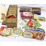 A box containing a collection of vintage food and drink labels, matchbox covers, cigarette packs and