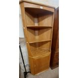 A 74cm Ercol light elm freestanding two part corner unit with two shelves and single cupboard door