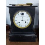 A late Victorian black slate cased mantel clock with eight day bell striking movement