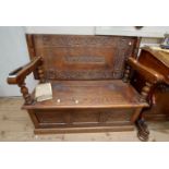 A 1.1m late Victorian carved oak monk's bench with central text panel 'Virtute Quies' (In Virtue