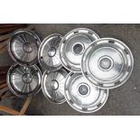 Seven assorted vintage car wheel hubs comprising one set of four and three others