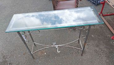 A wrought iron side table with glass top