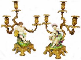 A pair of antique Meissen porcelain figurines depicting a lady eating grapes and a boy holding wheat