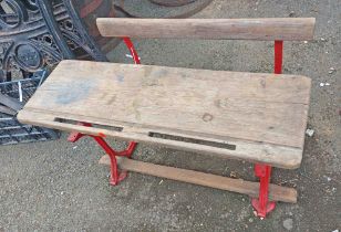 A Vintage school desk of bench form, with wooden top and bench, set on a cast-iron base