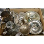 A box containing a quantity of silver plated items including chambersticks, tankards, etc.