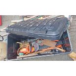 A large plastic lidded chest containing a quantity of tools, hedge trimmer, wrought iron house sign,