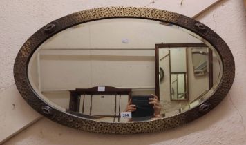 An 80cm early 20th Century brass clad framed bevelled oval wall mirror with applied decorative