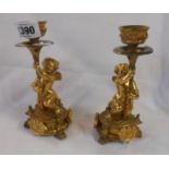 A pair of small ormolu candlesticks of cherub form