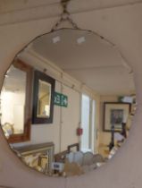 A vintage frameless wall mirror with decorative cut border to the circular plate