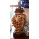 A modern Chinese pottery table lamp of lidded jar form, with typical decoration, set on hardwood