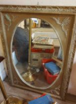An antique style gilt framed wall mirror with decorative border and oval plate