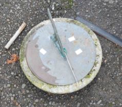 An old sun dial with chased decoration and cast gnomon, set on a stone base