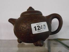 A Chinese Yixing Zisha clay teapot with molded and carved decoration and impressed square