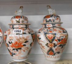 A pair of 18th Century Japanese Imari lidded jars each with hand painted iron red, cobalt blue,