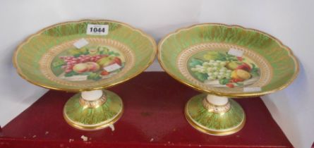 A pair of 19th Century porcelain dessert comports with central hand painted fruit decorated panel on