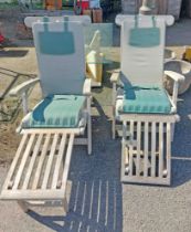 A pair of teak garden chairs of steamer style, with green cushions