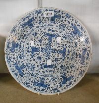 An 18th Century English delftware charger with painted blue stylised leaf decoration