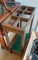 A vintage polished oak stick stand with moulded supports and metal drip tray