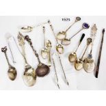 A bag containing small silver cutlery items including spoons and sugar tongs, some enamelled