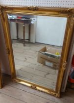 A large modern gilt framed bevelled oblong wall mirror in the antique style