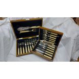A vintage stained wood canteen containing a set of six each silver plated fish knives and forks with