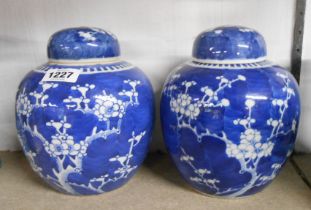 A pair of Chinese porcelain ginger jars and lids with prunus decoration - one with four character