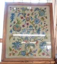 An oak framed and glazed tapestry depicting foliage and flowers